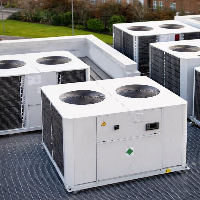Multiple commercial heat pump units installed across a rooftop